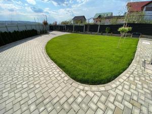 a brick walkway in a yard with a green lawn at Lora Studio in Suceava