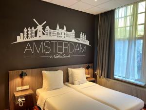 
a hotel room with a bed, desk and a painting on the wall at Mozart Hotel in Amsterdam
