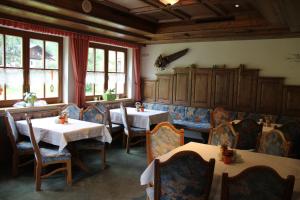 ein Restaurant mit 2 Tischen, Stühlen und Fenstern in der Unterkunft Hotel Winklerhof in Holzgau