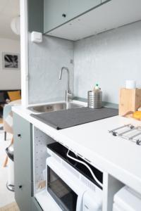 a white kitchen with a sink and a counter at Sublime 30m In The Heart Of Paris in Paris