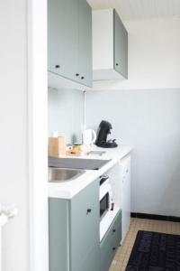a kitchen with white cabinets and a sink at Sublime 30m In The Heart Of Paris in Paris