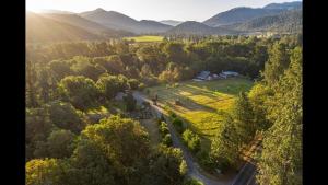 an aerial view of a farm with mountains in the background at Cozy Wild West Covered Wagon next to River in Grants Pass