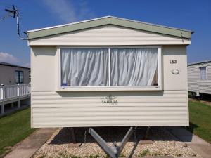 a small house with a window in a yard at 8 Berth The Chase Ingoldmells Sahara Super in Ingoldmells