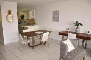 eine Küche und ein Esszimmer mit einem Tisch und Stühlen in der Unterkunft Appartement standing 2 chambres vue mer RES TAHIRI 3 in Punaauia