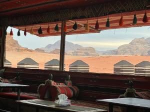 
a man sitting at a table in front of a train at Bedouin Roads in Wadi Rum

