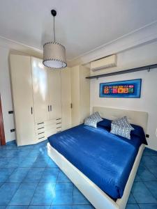 Un dormitorio con una cama azul y una lámpara de araña. en Augusto Capri Apartment, en Capri
