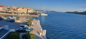 eine Gruppe von Autos, die neben einem Wasserkörper geparkt werden in der Unterkunft Villa Ana in Vodice