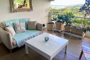 Una sala de estar con un sofá y una mesa de café. en Grand Studio Les Horizons Papeete, en Papeete