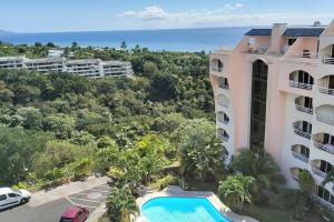 an aerial view of a resort with a swimming pool and the ocean at Grand Studio Les Horizons Papeete in Papeete