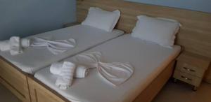 - un grand lit blanc avec des serviettes et des oreillers dans l'établissement Vasili Apartments, à Saranda