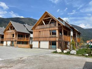 a large wooden building with mountains in the background at Sunny Retreat Apartment in Kranjska Gora
