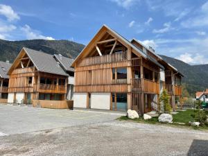 een groot houten gebouw met bergen op de achtergrond bij Sunny Retreat Apartment in Kranjska Gora