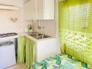 a kitchen with a sink and a green shower curtain at Casa Ninetta - Immobilevante in Ponza