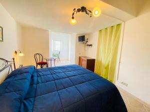 a bedroom with a blue bed and a table at Casa Ninetta - Immobilevante in Ponza
