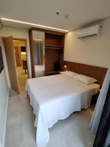 uma grande cama branca num quarto de hotel em Salinas Premium Resort - Flat em Salinópolis
