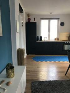 ein Wohnzimmer mit einer Küche mit blauer Wand in der Unterkunft Fewo Grünstrand in Cuxhaven