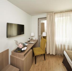 a hotel room with a desk and a bed at Art Hotel Aachen in Aachen