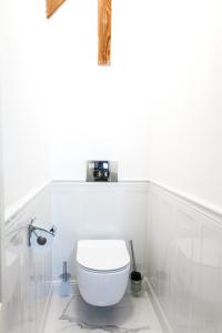 a white bathroom with a toilet in a room at VILLA RED by COLUMBUS Ustka in Ustka