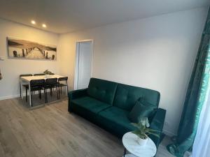 a living room with a green couch and a table at Apartament 80’s in Kołobrzeg