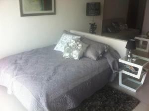 ein Schlafzimmer mit einem Bett, auf dem eine Blume liegt in der Unterkunft Amara Cancun Beachfront Condo in Cancún