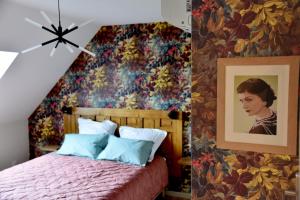 um quarto com uma cama com papel de parede floral em Au Relais de Laborde em Saint-Germain-les-Vergnes