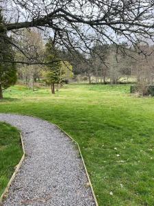 żwirowa ścieżka w parku z trawnikiem w obiekcie Cosy Cottage in beautiful Royal Deeside w mieście Aboyne