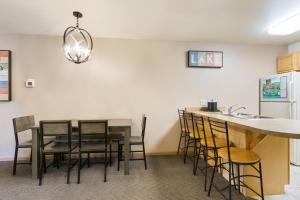 cocina con mesa, sillas y fregadero en Timber Ridge Lodge and Waterpark, en Lake Geneva