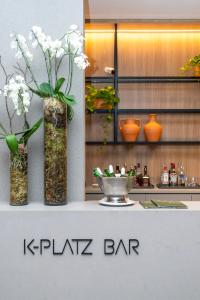 Drei Vasen mit Blumen darin auf einer Theke in der Unterkunft K-Platz Florianópolis São José in São José