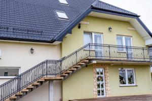 a yellow house with stairs on it at Pokoje Gościnne Katarzyna Kur in Dębki