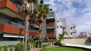 um edifício de apartamentos com palmeiras e uma piscina em Rota Mar em Rota