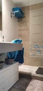 W łazience znajduje się przeszklony prysznic z niebieskimi ręcznikami. w obiekcie Rota Mar w mieście Rota