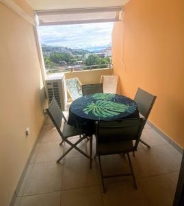 a dining room with a table and chairs and a window at Recent Bel Appartement une chambre Papeete in Papeete