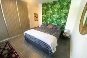 um quarto com uma cama com uma parede verde em Recent Bel Appartement une chambre Papeete em Papeete