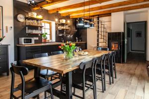 una cucina e una sala da pranzo con tavolo e sedie in legno di Škorničkův statek - Tátova chalupa s wellness za příplatek a Hamr