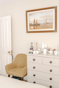 a bedroom with a dresser and a painting on the wall at Bridge House B & B Grassington in Grassington