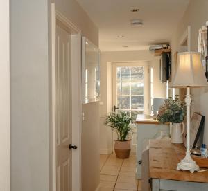 eine Küche mit einer Tür, einem Tisch und einer Lampe in der Unterkunft Bridge House B & B Grassington in Grassington