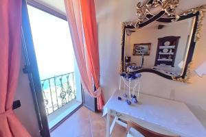 een kamer met een spiegel, een tafel en een raam bij B&B Casa Angelieri in Pizzo