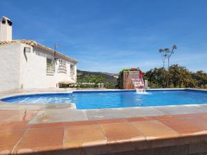 a swimming pool with a fountain in front of a house at Casa Carmen, Montefrio in Montefrío