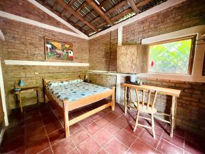 a room with a bed and a table and a window at Jungle Cabins El Escondido in Muy Muy +26 photos