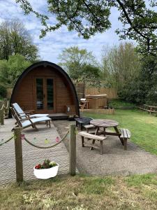 Cabaña de madera con mesa de picnic y banco en Ty Cnocell, en Boncath
