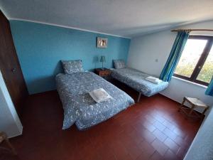 a small bedroom with two beds and a window at Cool Villas T2 in Sagres