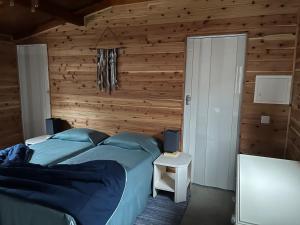 a bedroom with a bed and a wooden wall at A Cabana in Angra do Heroísmo