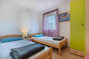 Posteľ alebo postele v izbe v ubytovaní Apartmani Utmar Cres