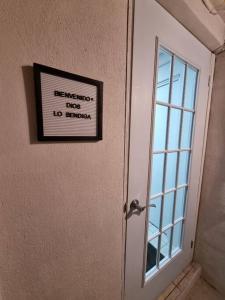 een bord op de deur van een kamer met een raam bij ACOGEDOR APT/STUDIO EN LA CIUDAD DE SANTA TECLA in Nueva San Salvador