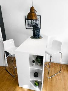un tavolo bianco con due sedie e un vaso sopra di Schickes Appartement in Wuppertal-Ronsdorf Whg. 66 a Wuppertal