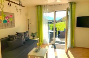 a living room with a couch and a sliding glass door at Ferienwohnungen Apart Diana in Vils