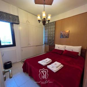 a bedroom with a red bed with two towels on it at Saint Michel Chalets in Al Arz