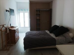 um quarto com uma cama, uma cómoda e uma janela em Agréable maison de ville tout confort em Loudun