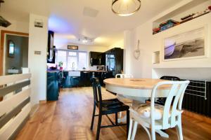 a kitchen and dining room with a table and chairs at Pebbles Beach House By Air Premier in Seaford