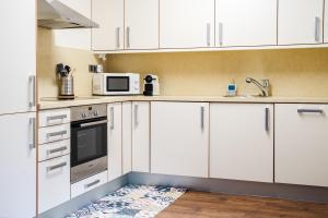 a white kitchen with white cabinets and a microwave at Apartamento Luxury en Bordes d'Envalira, Andorra in Soldeu